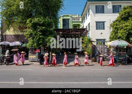 Monache buddiste che raccolgono elemosine nelle strade di Yangon, Myanmar Foto Stock