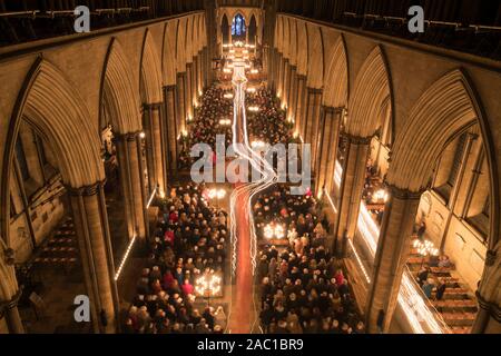 Candele sono trasportate attraverso la Cattedrale di Salisbury durante l avvento processione ha chiamato dalle tenebre alla luce illuminando la 800-anno-vecchio edificio medievale come tutte le elettrici e le luci artificiali sono disattivati durante il servizio. Foto Stock