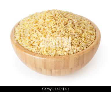 Non cotti bulgur in ciotola di legno isolato su sfondo bianco con tracciato di ritaglio Foto Stock