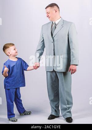 Stare insieme. fiducia e valori. padri giorno. Il giorno della famiglia. Il padre ed il figlio in business suit. moda maschile. bambino felice con il padre. business partner. piccolo ragazzo medico con papà imprenditore. l'infanzia. Foto Stock