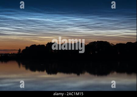 Blu nubi argenteo o noctilucent nuvole o di notte splende nuvole sopra un lago in Olanda. Paesaggio panoramico durante il crepuscolo. Foto Stock