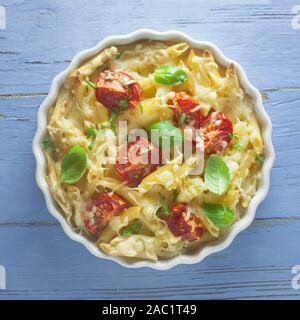 Gratin di pasta in una teglia da forno su uno sfondo blu Foto Stock