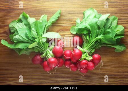 Due mazzetti di ravanelli su uno sfondo di legno Foto Stock