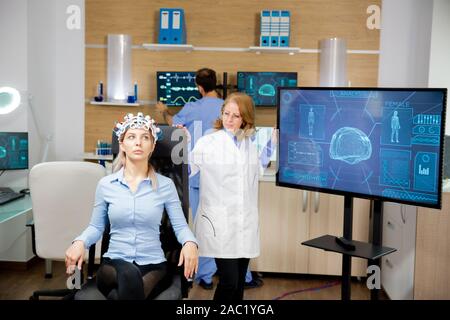 Medico paziente tracking evoluzione nel corso di neurologia prova auricolare. Centro Neorological Foto Stock