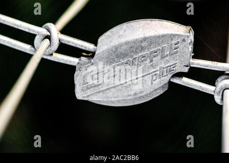 Close-up di un Gripple filo joiner attaccato ad un filo di acciaio scherma. Foto Stock
