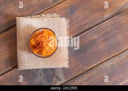 Ciotola di vetro di fatti in casa marmellata di carote con carote e arancione su sfondo di calcestruzzo Foto Stock