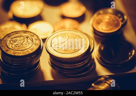 Pile di ferro di monete d'oro sul tavolo Foto Stock