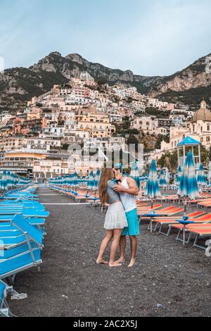 Positano, Italia - 14 agosto 2019: Coppia eterosessuale bacio sulla spiaggia di Positano al mattino Foto Stock