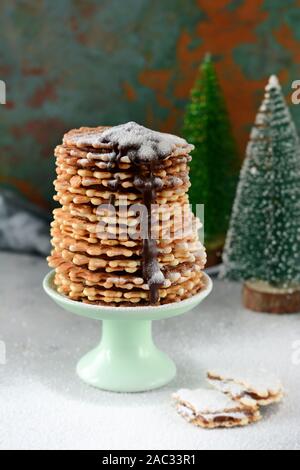 Una pila di cialde olandese salate con caramello su sfondo grigio. Cialde dolci dessert. Waffle belgi. Sfondo di natale con biscotti di Natale Foto Stock