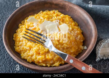 Porzione di risotto alla zucca decorata witn fette di parmigiano Foto Stock