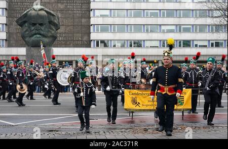 Chemnitz, Germania. 30 Novembre, 2019. I minatori associazioni passano per il monumento a Karl Marx durante la grande parata di montagna del Erzgebirgische Bergbrüderschaften attraverso il centro della citta'. Circa 700 uniforme di indossatori e circa 400 mountain musicisti e cantanti prendere parte al tradizionale ascensore. Credito: Pietro Endig/dpa-Zentralbild/dpa/Alamy Live News Foto Stock