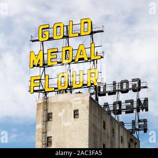 Il giallo medaglia d oro farina insegne al neon sulla sommità di elevatori delle granaglie che sono ora parte del Mulino storico del Museo della città nel centro di Minneapolis, Minnesota Foto Stock