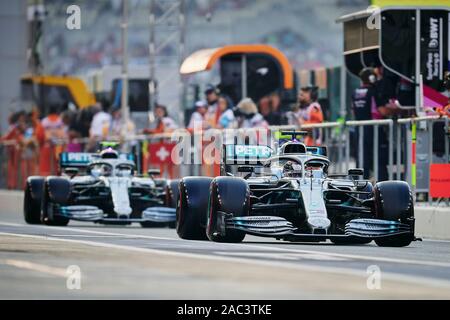 Mercedes AMG Petronas F1 del Team driver britannico Lewis Hamilton (anteriore) e la Mercedes AMG Petronas F1 del Team pilota finlandese Valtteri Bottas drive sulla pit lane durante la sessione di qualifiche di Abu Dhabi Grand Prix F1 al circuito di Yas Marina di Abu Dhabi. Foto Stock