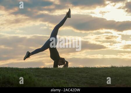 Giovane donna facendo appoggiate sull'erba mattina allenamento bellissima alba Foto Stock