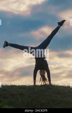 Giovane donna facendo appoggiate sull'erba mattina allenamento bellissima alba Foto Stock