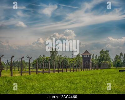 Oświęcim, Polonia - 05 Giugno 2019: recinto elettrico con il filo spinato e torre di avvistamento al Campo di Concentramento di Auschwitz-Birkenau in Oświęcim, Polonia. Unione europea Foto Stock