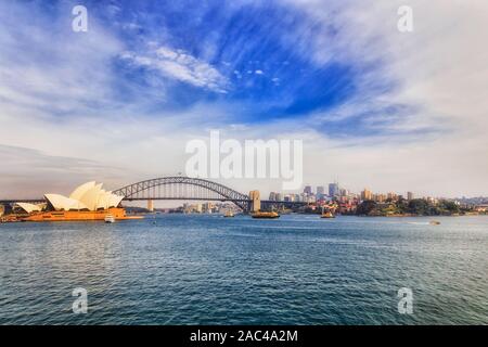 Regolare Ferry di Sydney sul percorso di banchine intorno al Porto di Sydney in una giornata di sole di fronte arco in acciaio del ponte di Sydney e North Shore. Foto Stock