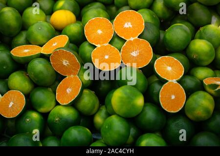 Appena raccolto green tangerini mandarini, clementine, come gli agrumi sfondo. Foto Stock