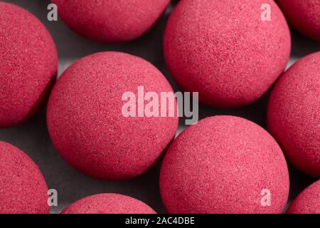 Bagno rosa bombe sul piano portapaziente grigio, vista ravvicinata Foto Stock