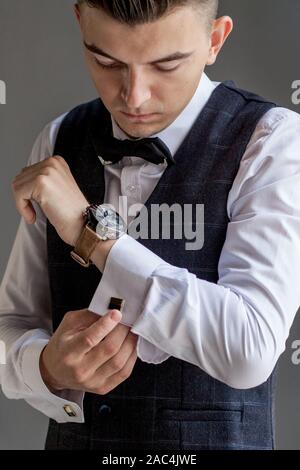 L'uomo diventa pronto per il lavoro da abbottonatura fino la sua camicia business. Lo sposo di mattina preparazione prima del matrimonio Foto Stock