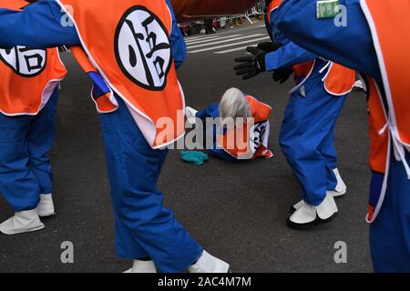 NEW YORK, NY - novembre 28: Gestore cadere mantenendo Goku da Toei Animation palloncino gigante bassa a causa del vento forte al 93annuale di Macy's Thanksg Foto Stock