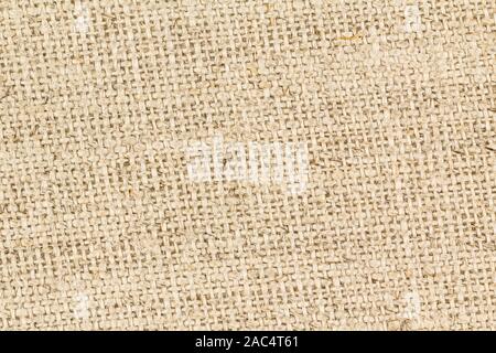 Close up sullo sfondo di un tessuto grossolanamente i filetti di iuta di tan tessuto di tela. AKA Hessian panno. Foto Stock