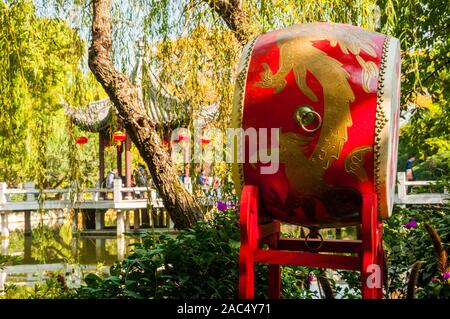 Un tradizionale stile Cinese rosso tamburo con un padiglione e ponte su un lago in background prese a Giardino Guyi, Shanghai. Foto Stock