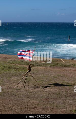 Bandiera hawaiana che soffia nel vento sulla costa Foto Stock