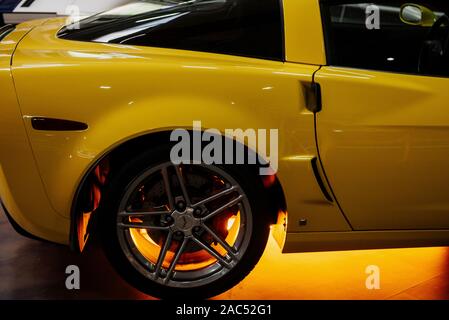 SINSHEIM, Germania - 16 ottobre 2018: Technik Museum. Lato di supporto del bellissimi e moderni giallo auto con luce al neon sotto di esso Foto Stock