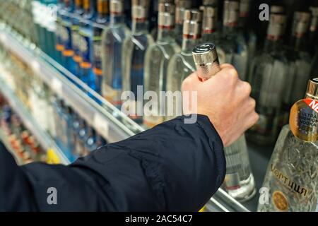 Ekaterinburg, Russia - Novembre 2019. File di bottiglie di alcol nel dipartimento del supermercato e la scelta di bevande forti, tenendo la vodka dal Foto Stock