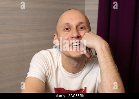 Ritratto di un sorriso bonario uomo giovane a casa. Foto Stock