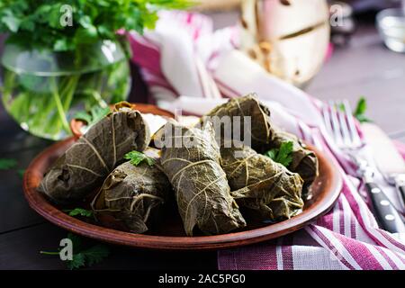 Dolma. Farcite le foglie di uva con riso e carne sul tavolo scuro. Cucina medio-orientale. Foto Stock