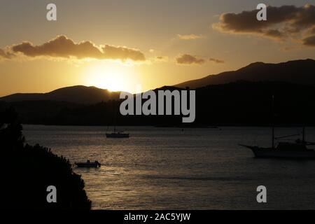 Il sole sorge da dietro le montagne sull'isola di Lefkada Grecia Foto Stock