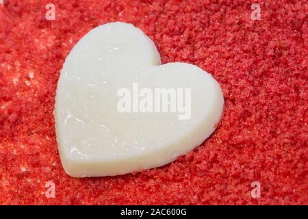 Closeup torta rossa del velluto con piastra in vetro. cuore sfondo. Adatto per l'occasione di San Valentino. Foto Stock