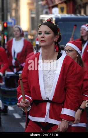 Liverpool, Regno Unito. Il 1 dicembre 2019. Una banda di Samba intrattiene migliaia di guide di scorrimento in rosso e blu Santa adatta per prendere parte all'annuale 5km Santa Dash. Credito: Ken Biggs/Alamy Live News. Foto Stock