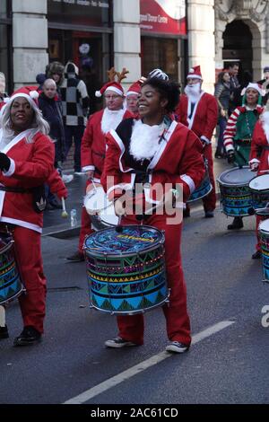 Liverpool, Regno Unito. Il 1 dicembre 2019. Una banda di Samba intrattiene migliaia di guide di scorrimento in rosso e blu Santa adatta per prendere parte all'annuale 5km Santa Dash. Credito: Ken Biggs/Alamy Live News. Foto Stock