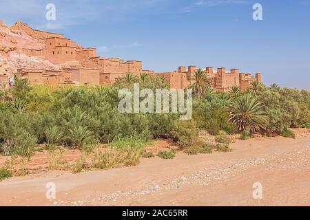 Vista di un essiccato fuori il letto del fiume con costruzioni fortificate e un oasi al ksar di Ait Benhaddou Foto Stock