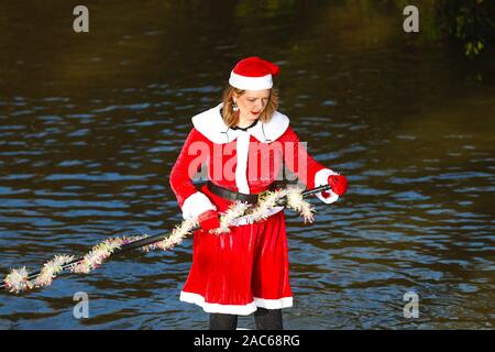 Tonbridge, Kent, Regno Unito. 01 dicembre 2019. Ora è il 9° anno la corsa per il cancro del paddleboard di santa è un evento caritativo iniziato da Jay Manning, un boarder professionista del paddle, che ha tenuto eventi simili in tutto il paese per gli ultimi nove anni. Questa volta l'evento si svolge sul fiume Medway a Tonbridge in Kent con un inizio di 12 ore, i membri del pubblico sono incoraggiati a guardare e donare a questo evento. © Paul Lawrenson 2019. Photo Credit: Paul Lawrenson/Alamy Live News Foto Stock