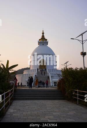 La pace mondiale Pagoda che si affaccia a Pokhara al tramonto Foto Stock