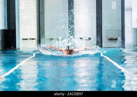 Professional nuotatore ginnastica in piscina interna. Foto Stock