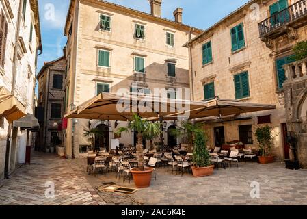 Cafe tavole su strada accogliente della città vecchia. Kotor, Montenegro Foto Stock