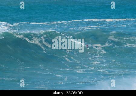 Pro surfer sulla enorme XXL 20-30 metri (70-100 piedi) onde Praia do Norte Nazare Portogallo Foto Stock