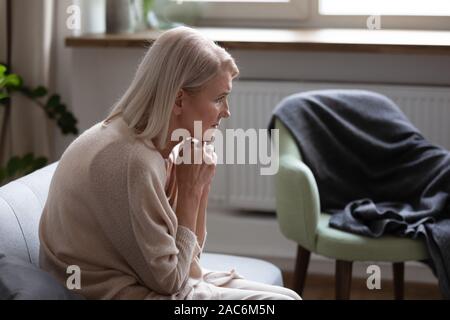 Età curvò la donna si sente sconvolto pensando seduto sul lettino Foto Stock