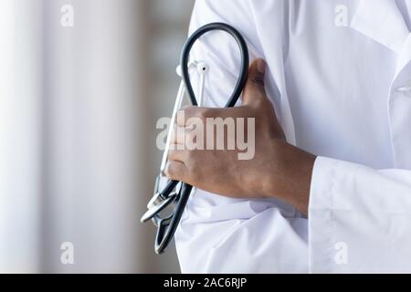 Close up americano africano giovani medici di sesso maschile mani, tenendo phonendoscope. Foto Stock