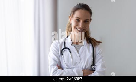 Sorridente e simpatico femmina giovane professionista medico fiducioso colpo alla testa. Foto Stock
