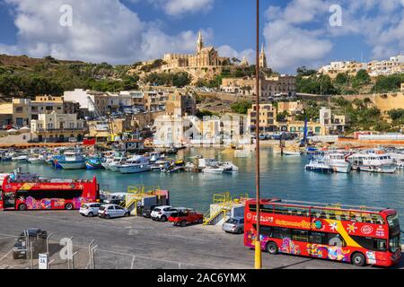 Città di Mgarr con gli autobus turistici in attesa per i turisti al porto di Gozo, regione settentrionale di Malta, un'isola nel mare Mediterraneo Foto Stock