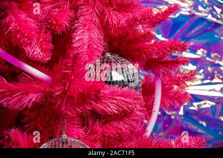La magia di Natale la sfera dello specchio pezzi su un albero di Natale artificiale vicino. discoteca 80-TH Foto Stock