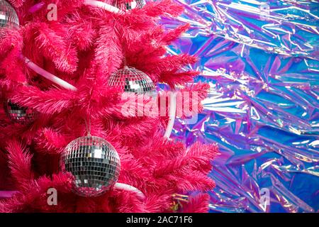 La magia di Natale la sfera dello specchio pezzi su un albero di Natale artificiale vicino. discoteca 80-TH Foto Stock
