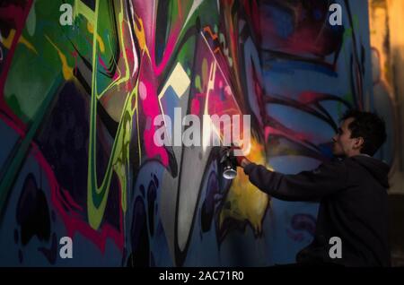 Pittore di graffiti sotto il ponte Siekierkowski, Varsavia, Polonia Foto Stock