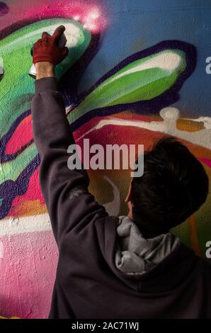 Pittore di graffiti sotto il ponte Siekierkowski, Varsavia, Polonia Foto Stock